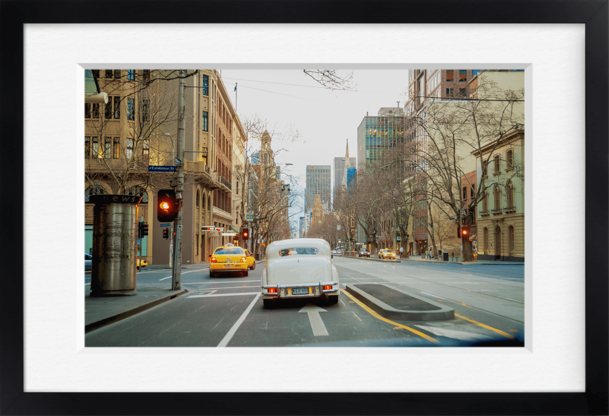 Framed archival print of a city street with a vintage white car and yellow taxis