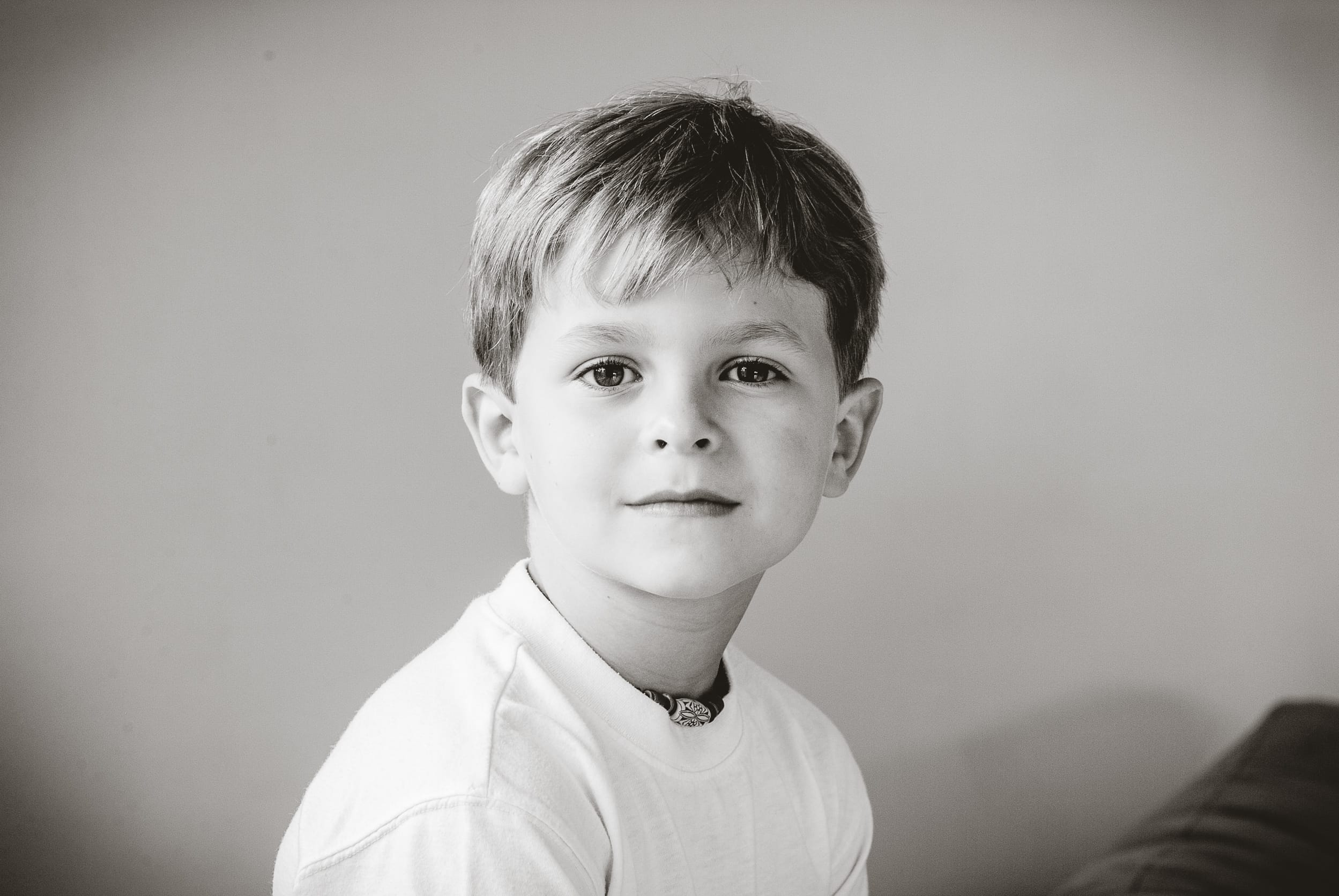 A black and white portrait of boy at home as part of a multi-generational family in Australia, captured with natural light for the 2026 Founder’s Residency by Arnold Szmerling.