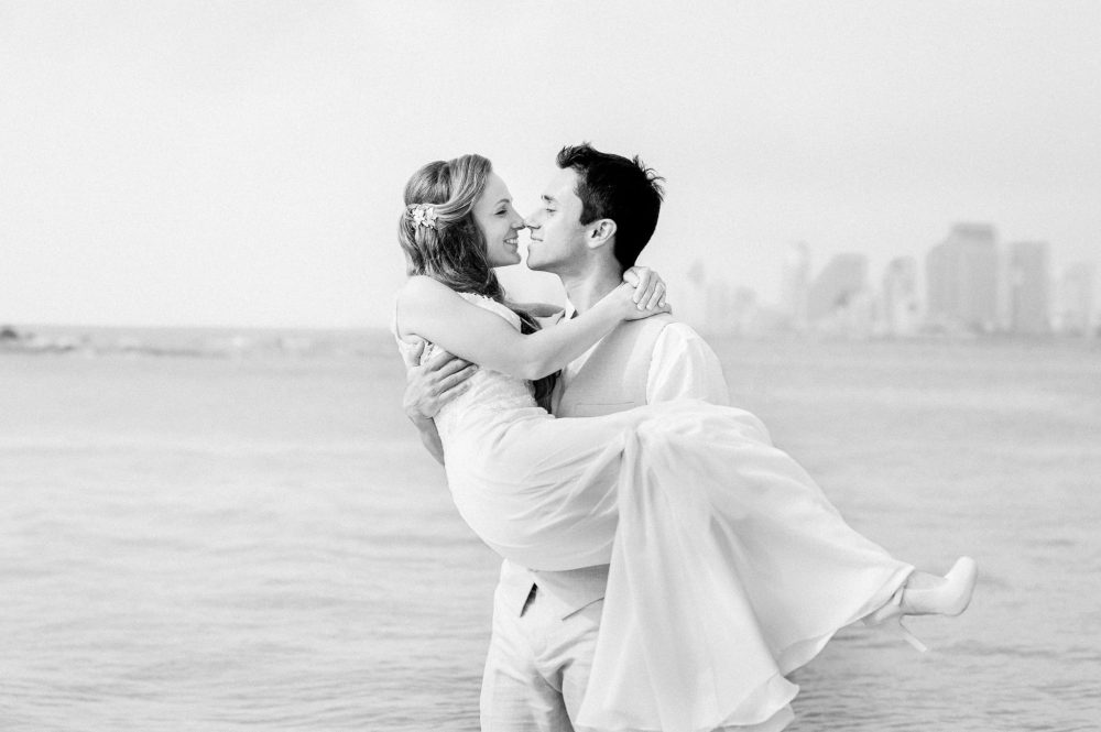 Romantic couple against the Tel Aviv skyline – intimate natural-light portrait by Arnold Szmerling