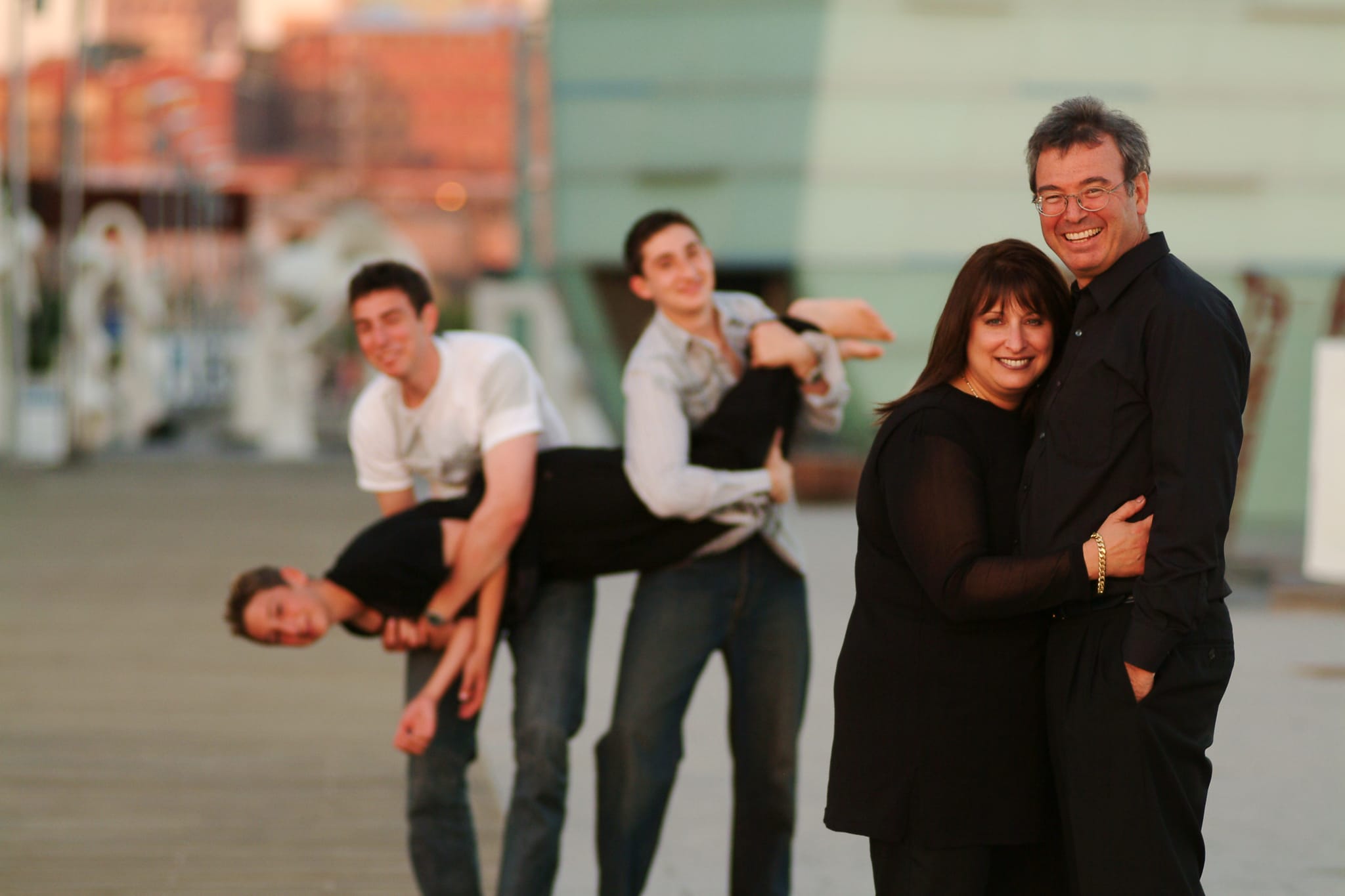 Parents smiling in the foreground while their three sons playfully clown behind them at Federation Square Melbourne — Arnold Szmerling Visual Legacy Artist