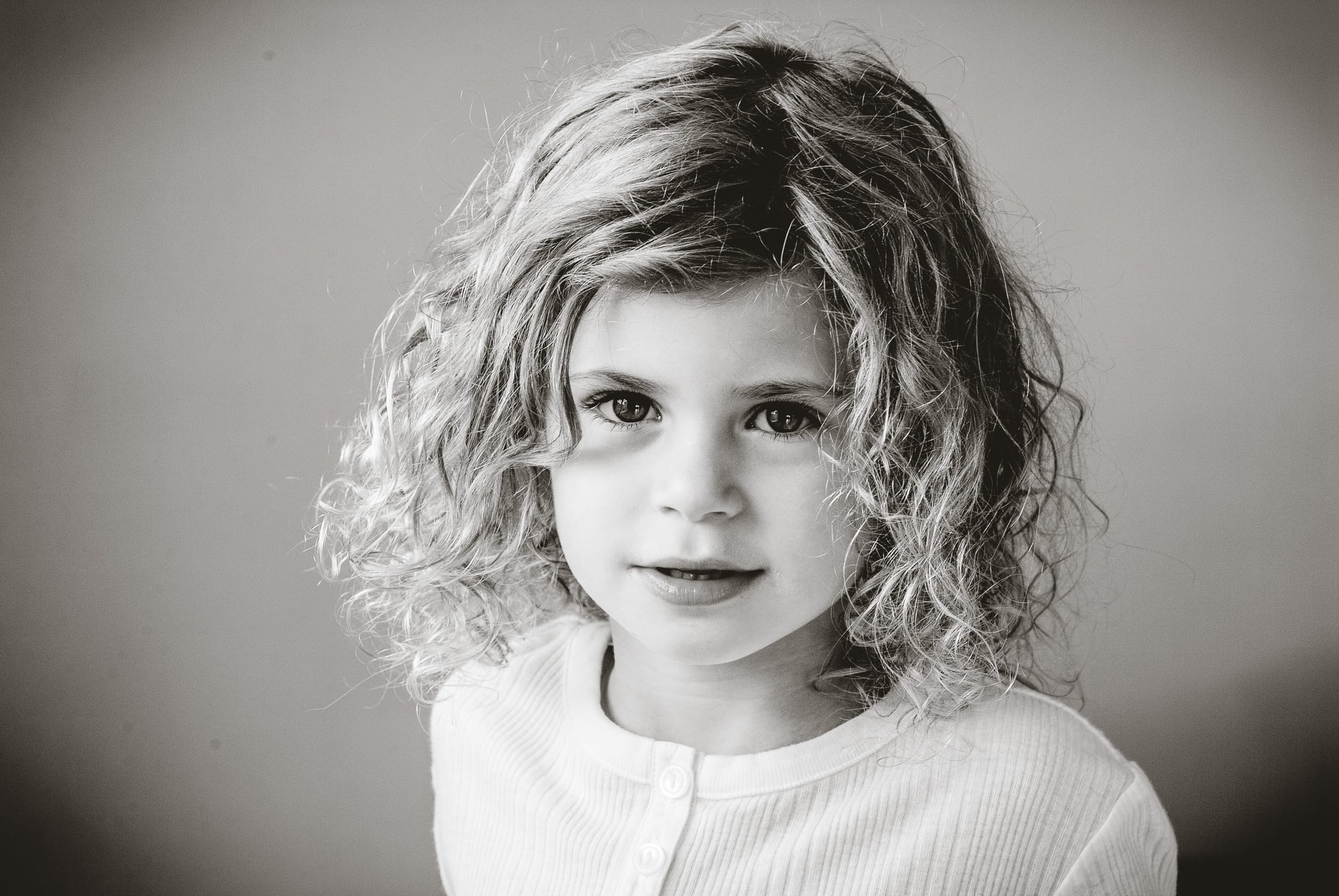 Gentle, contemplative black and white portrait of a young woman in her family home in Australia, belonging to a multi-generational lineage, photographed in natural window light for the 2026 Founder’s Residency by Arnold Szmerling.