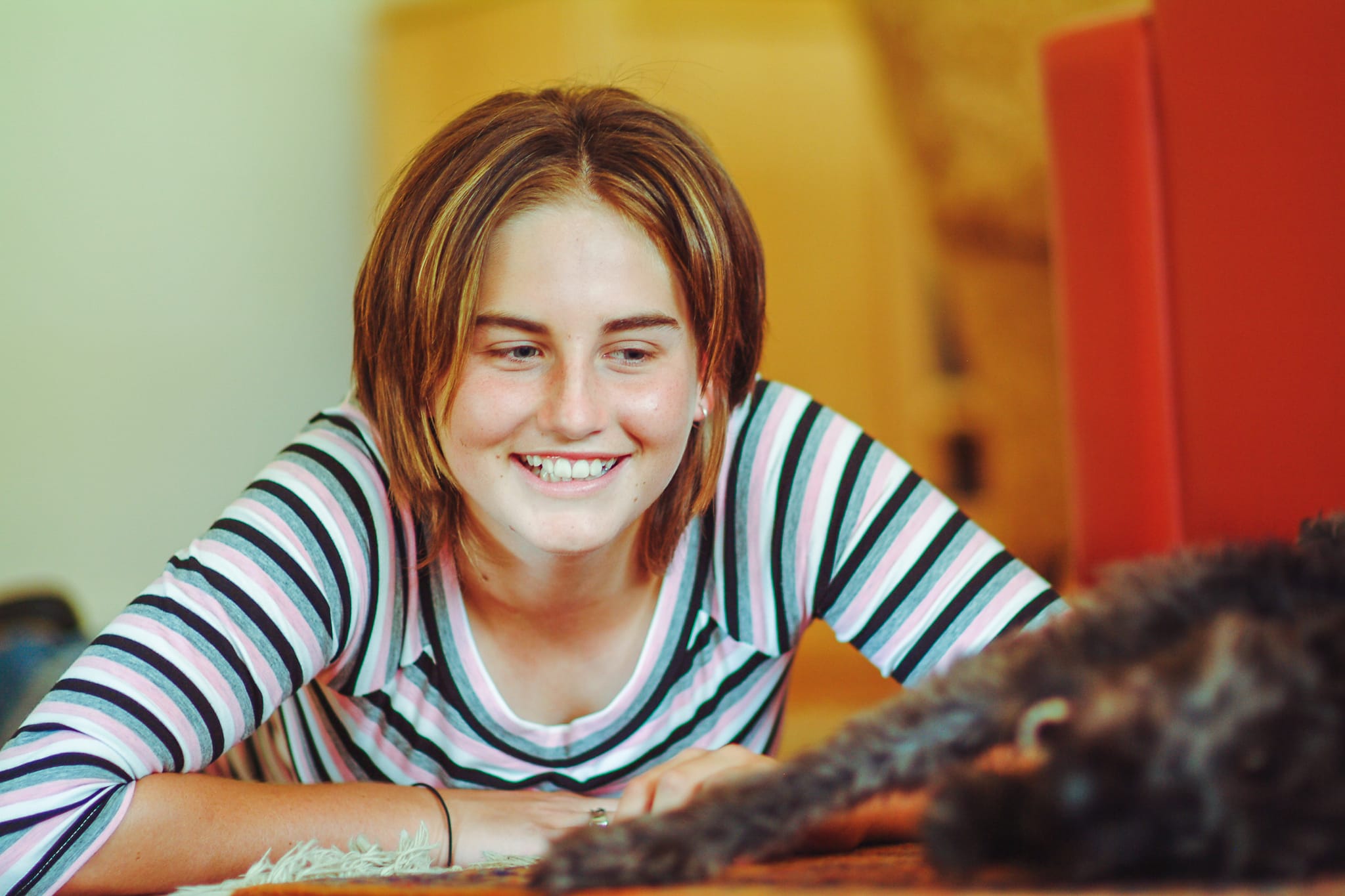 A young girl smiling warmly at her dog in a colour portrait — Arnold Szmerling Visual Legacy Artist