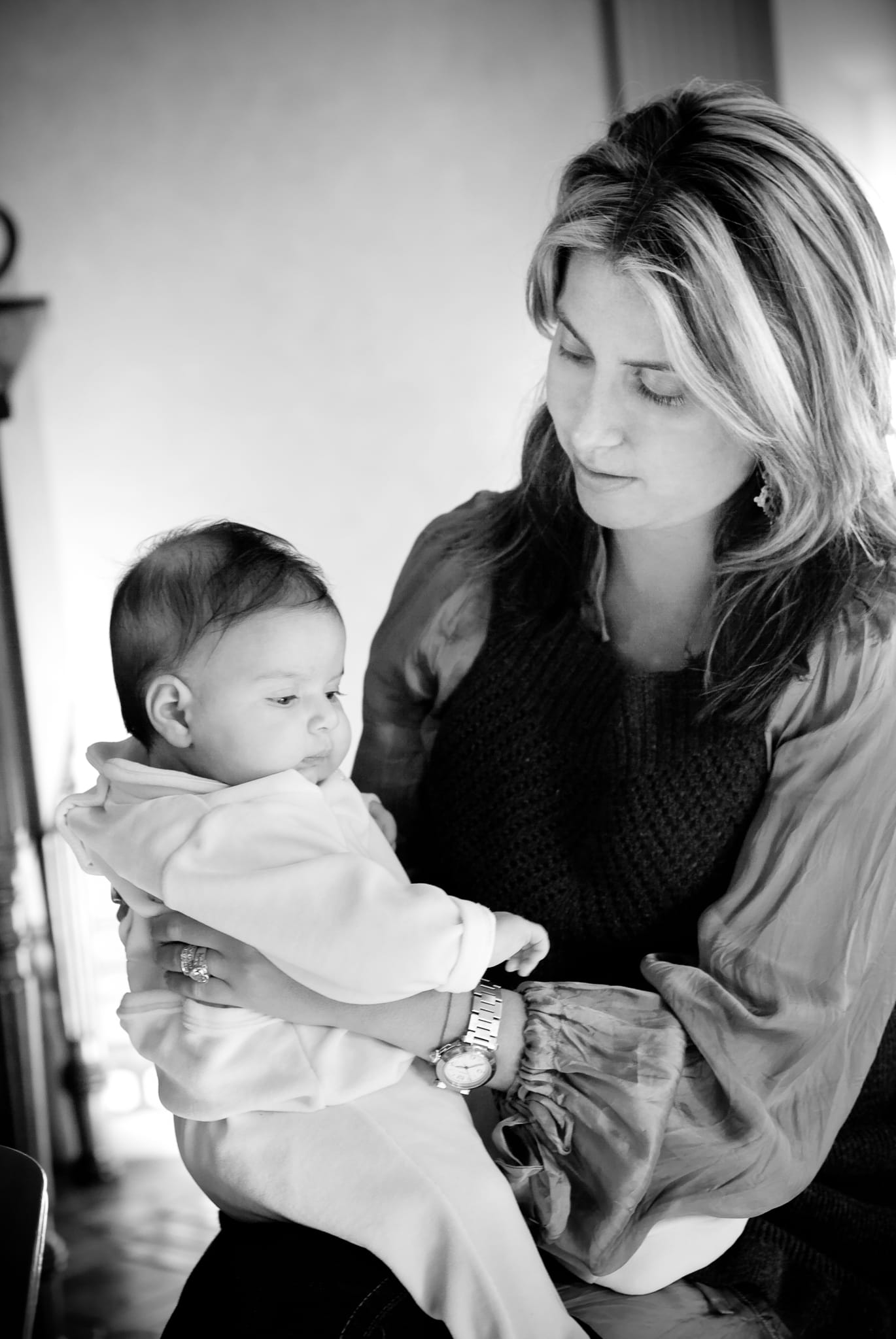 Black and white portrait of a mother gazing down at her newborn baby in natural window light — Arnold Szmerling Visual Legacy Artist
