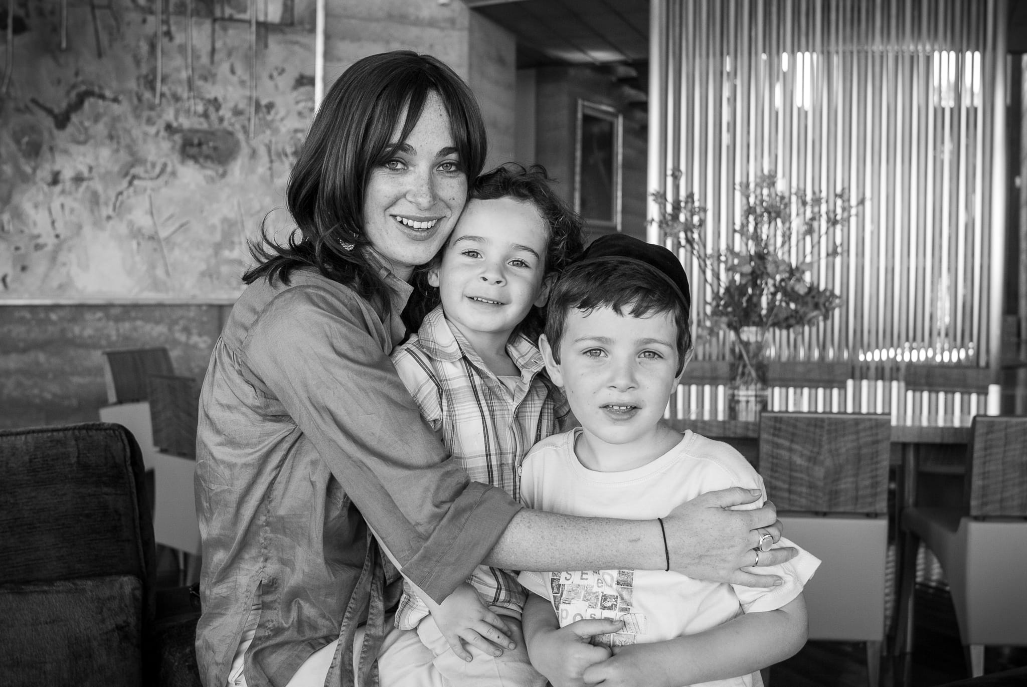 Warm, multi-generational moment of mother and sons in Melbourne – natural-light family portrait by Arnold Szmerling