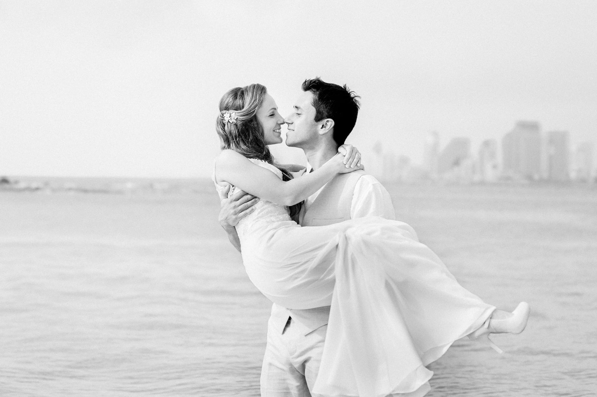 Romantic couple against the Tel Aviv skyline – intimate natural-light portrait by Arnold Szmerling