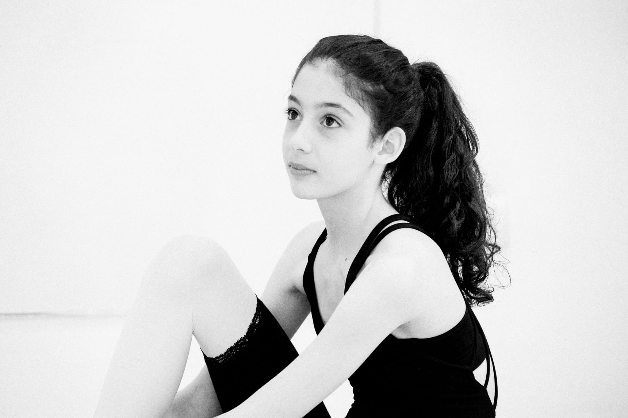 Fine art black and white portrait of a young ballet dancer seated on a studio floor — Arnold Szmerling Visual Legacy Artist