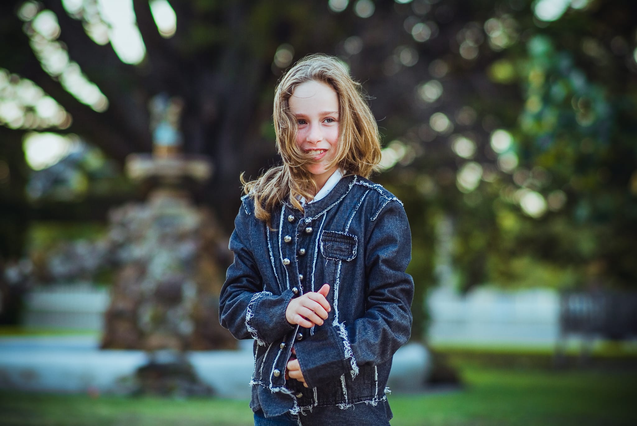 A young girl in a denim jacket in a garden, warm colour portrait — Arnold Szmerling Visual Legacy Artist